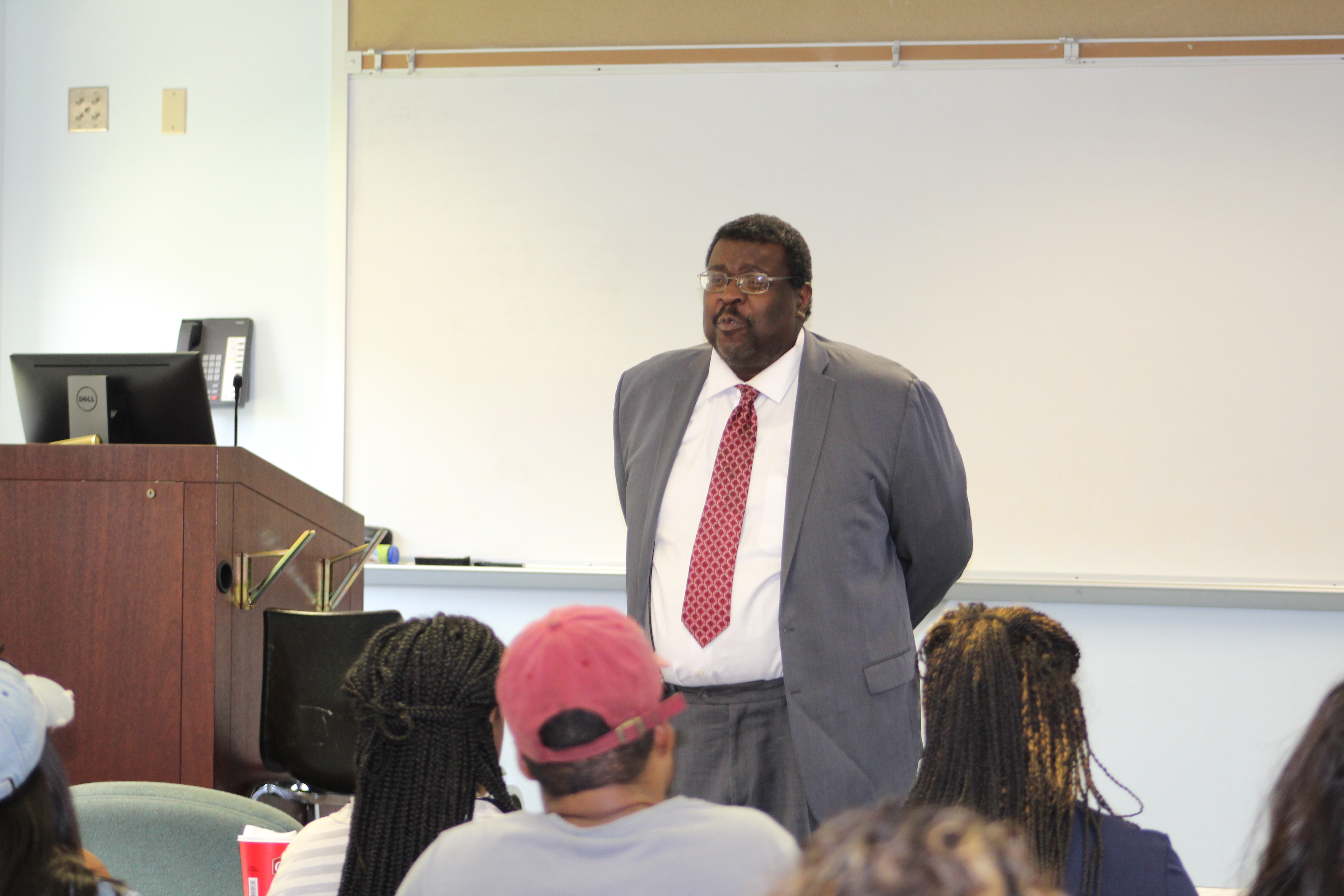 Male Professor in front of a class room talking to students